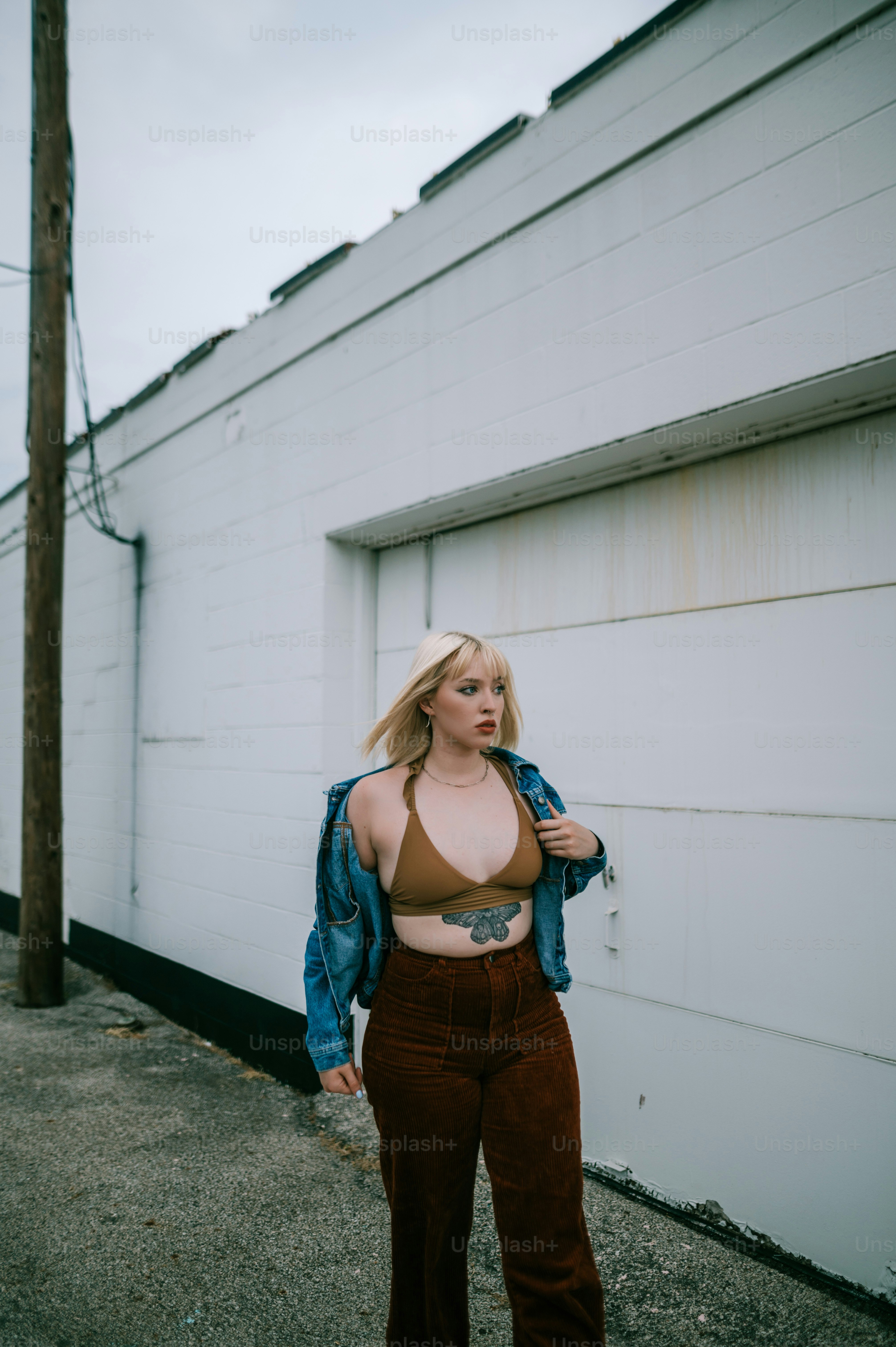 Une femme debout devant un bâtiment blanc