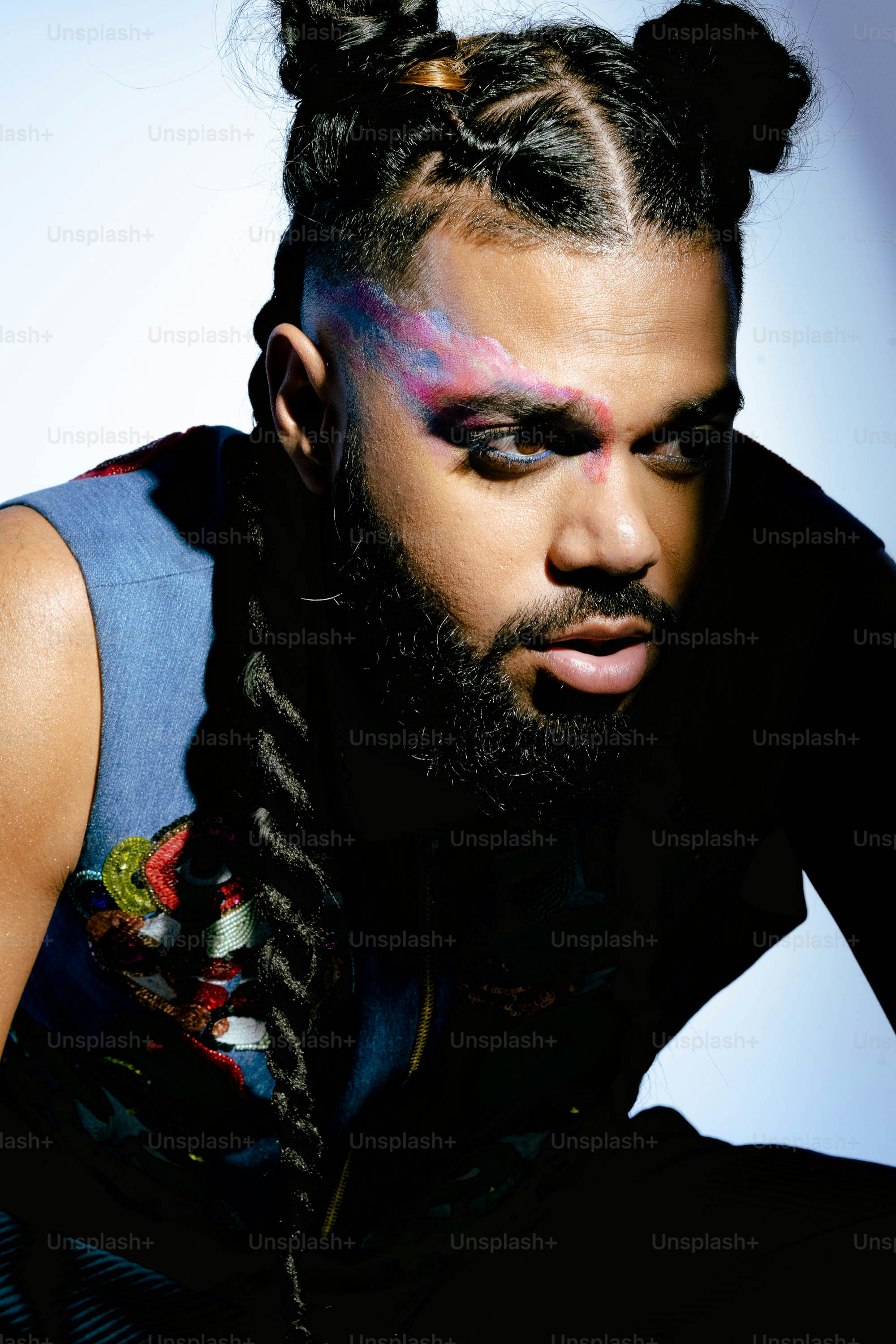 Un homme avec ses cheveux en chignon avec un visage peint