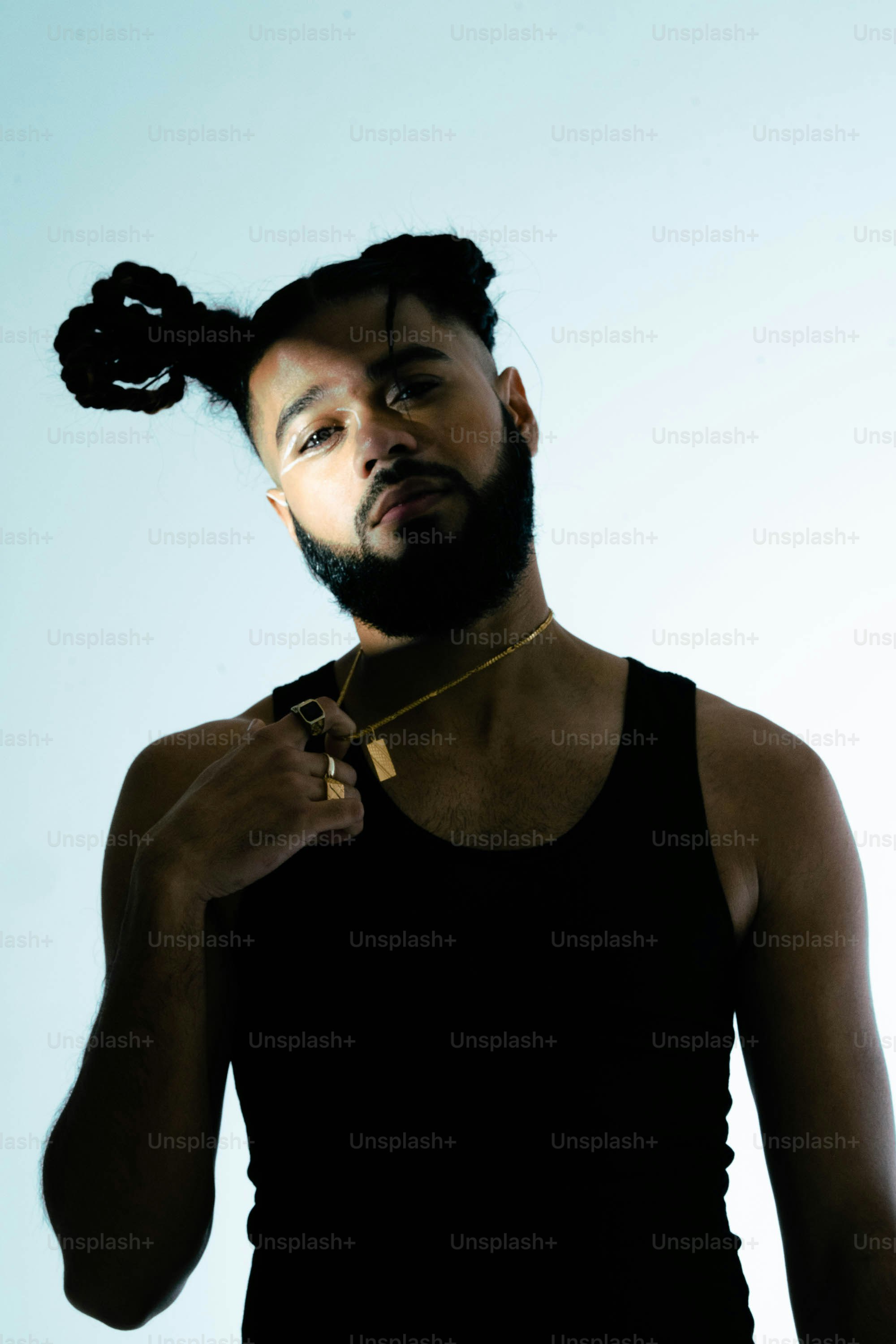 Un homme avec une chemise noire et un collier en or