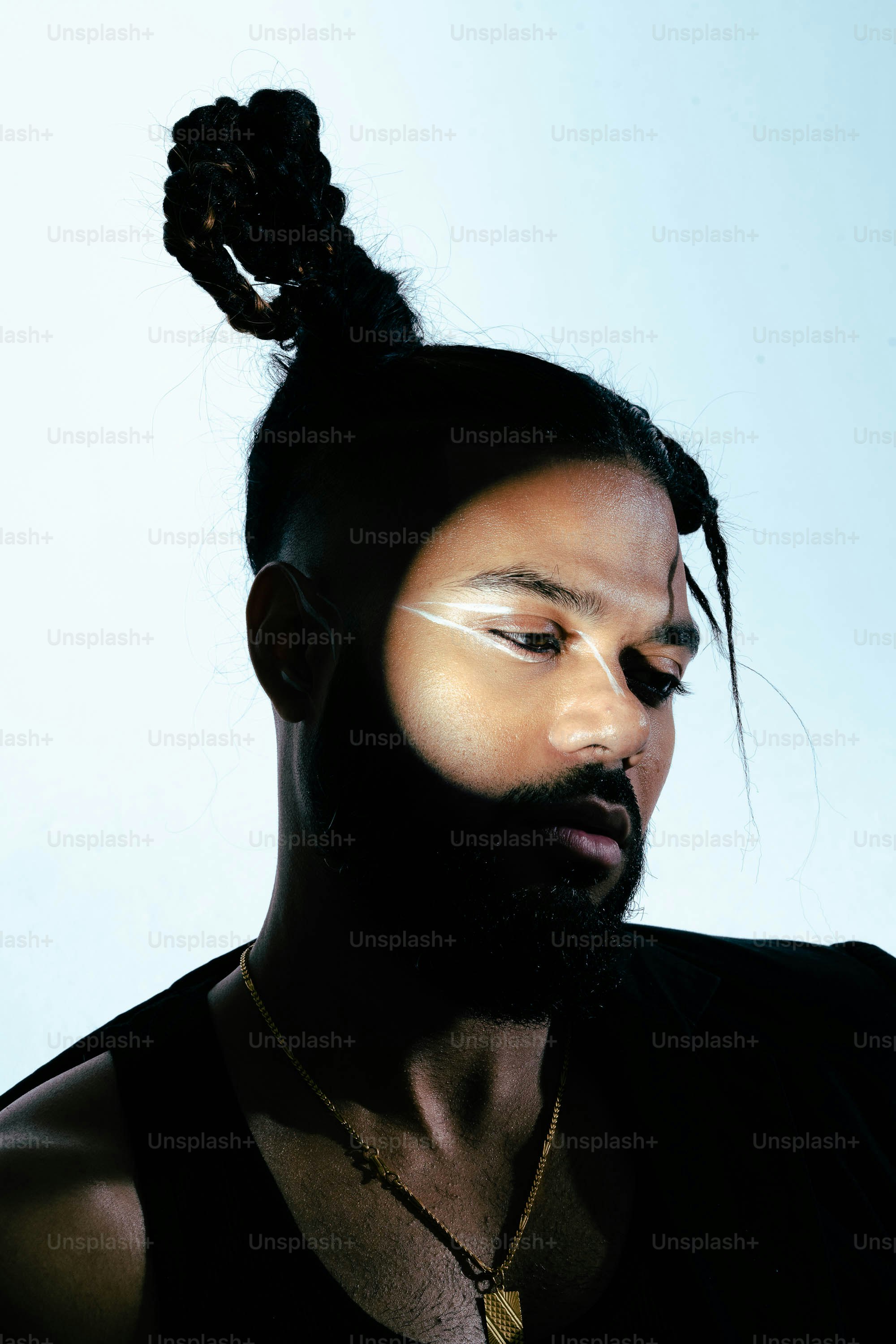 Un hombre con una cola de caballo y un collar