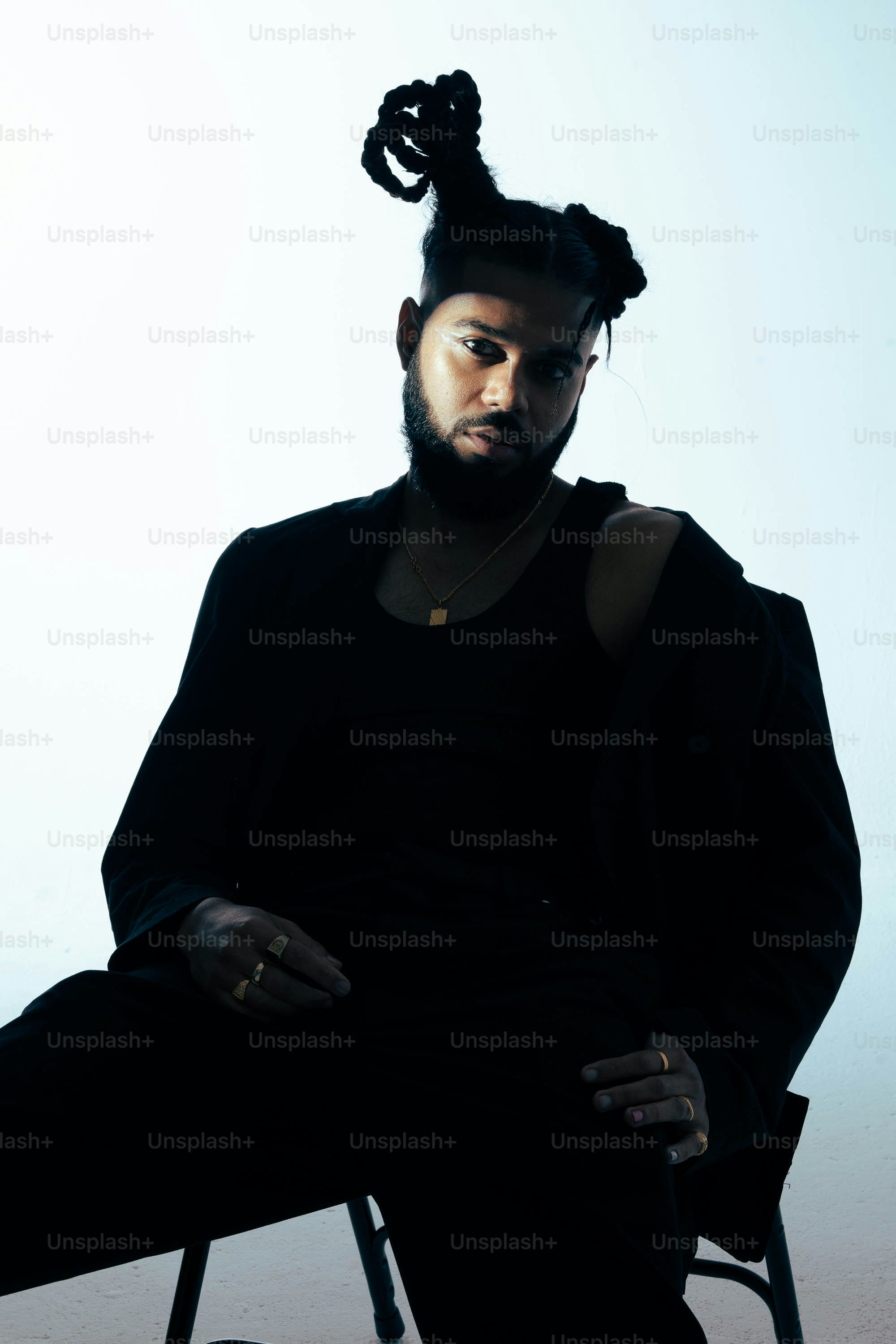 Un uomo seduto su una sedia con una coda di cavallo tra i capelli foto –  Immagine di Estetico su Unsplash, image size:3000x4500