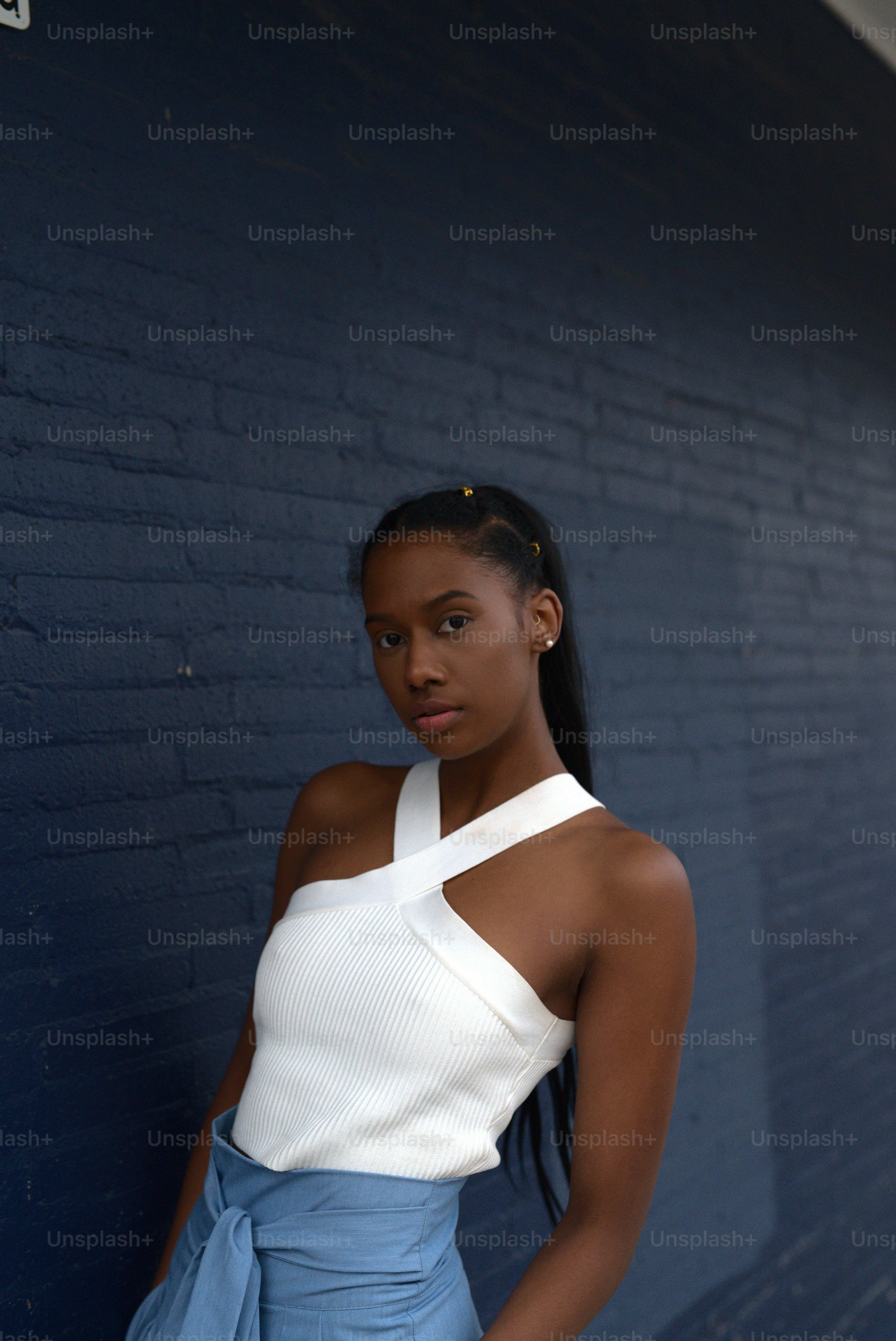 eine frau, die vor einer blauen wand steht