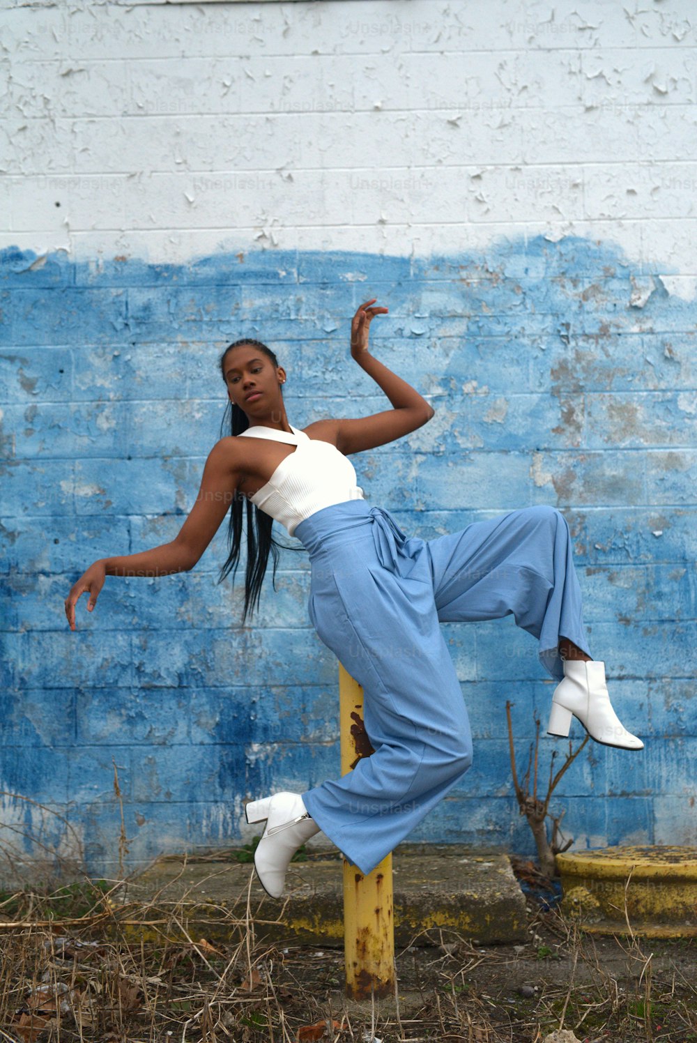 a woman in a white top and blue pants