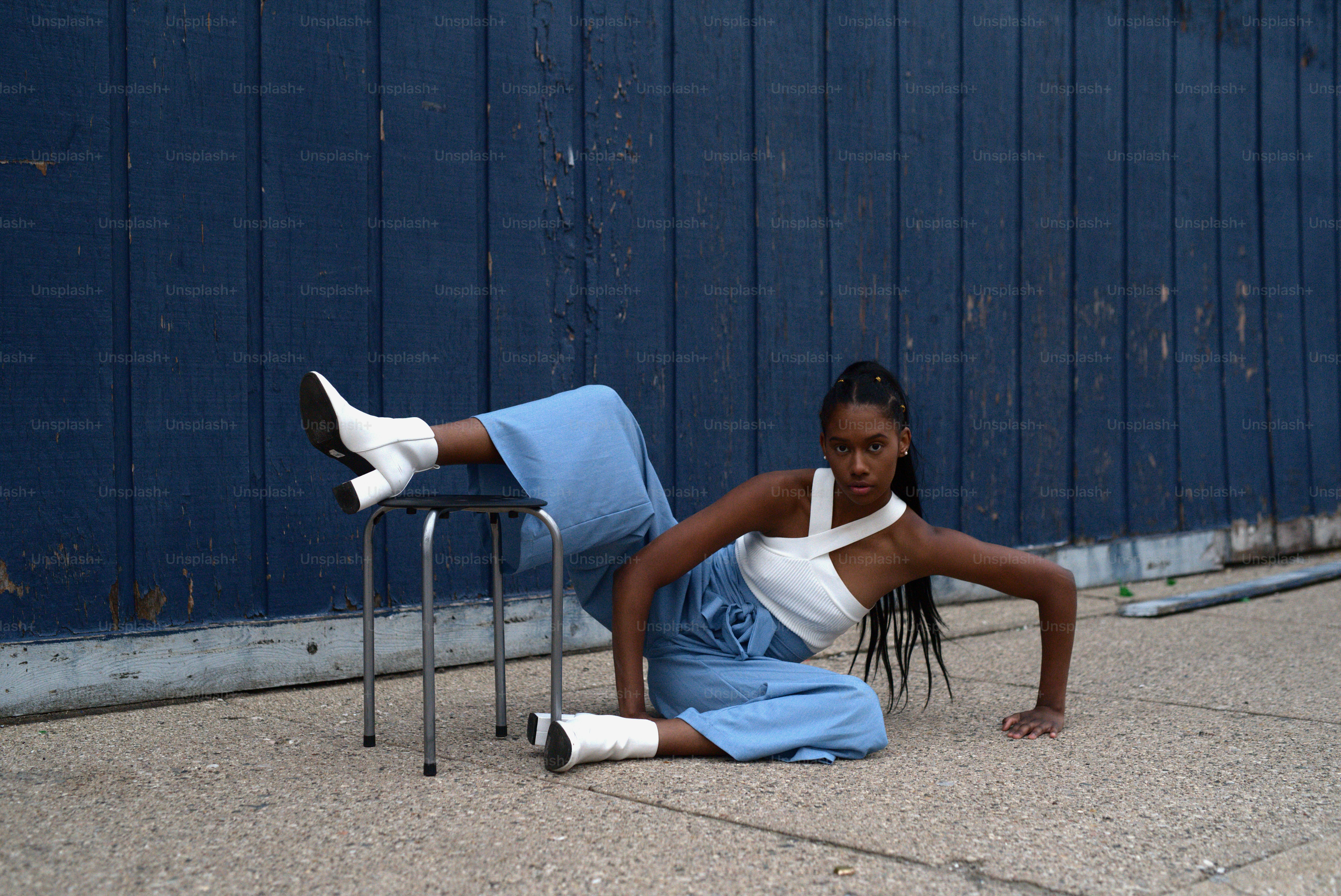 a woman sitting on the ground next to a chair