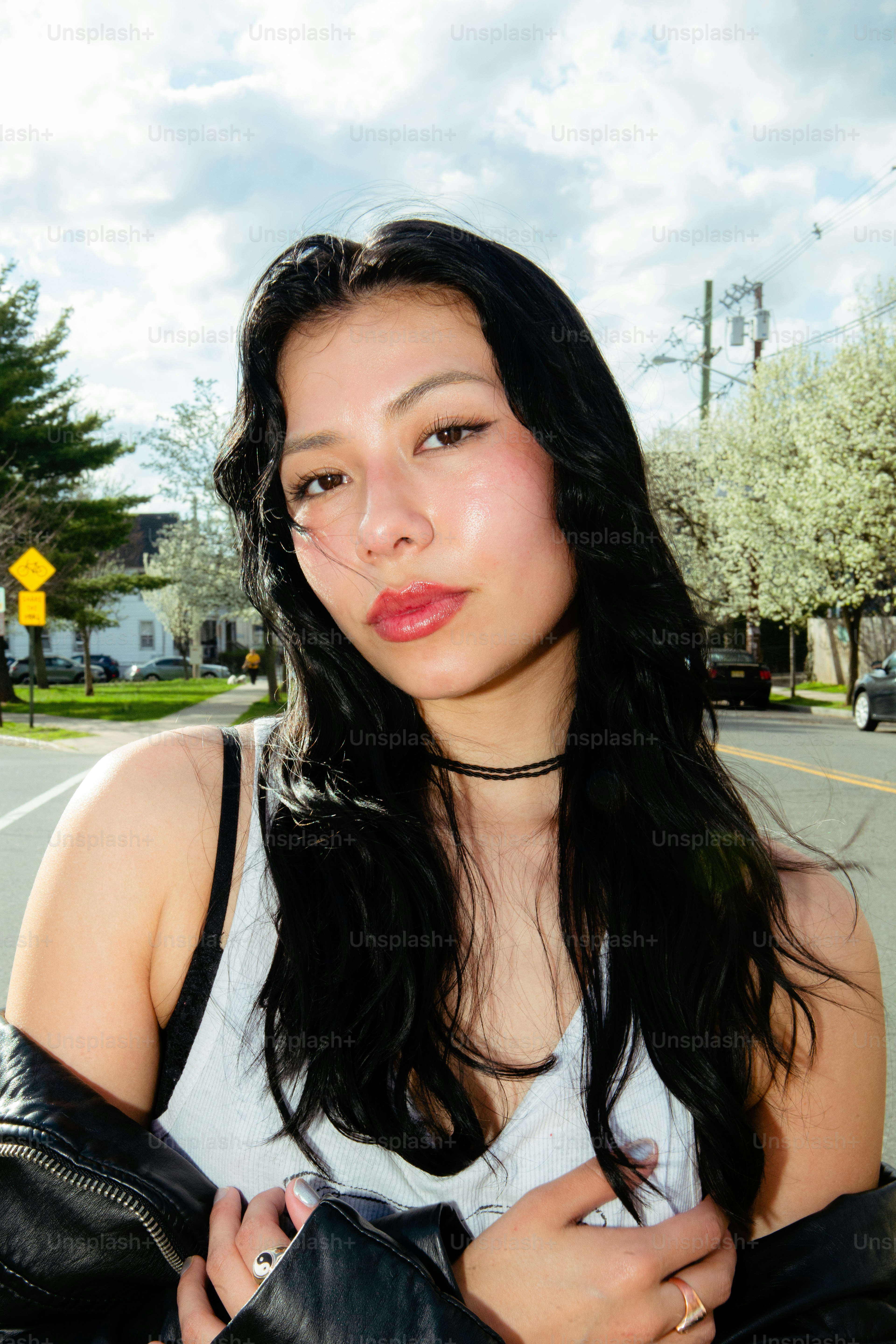 a woman with long black hair wearing a black leather jacket
