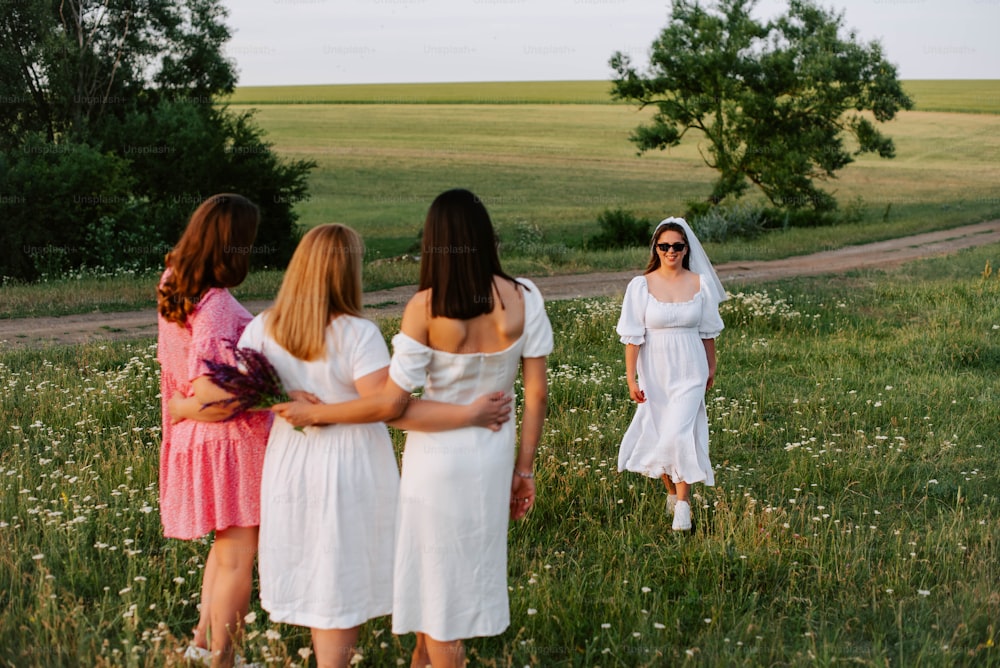 a group of women in white dresses standing in a field