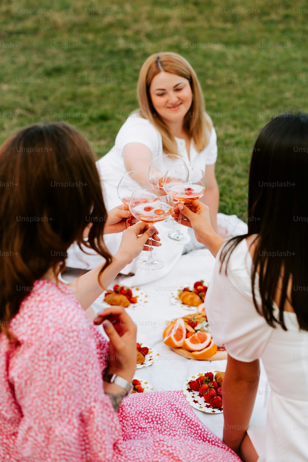 Un grupo de mujeres sentadas alrededor de una mesa con copas de vino