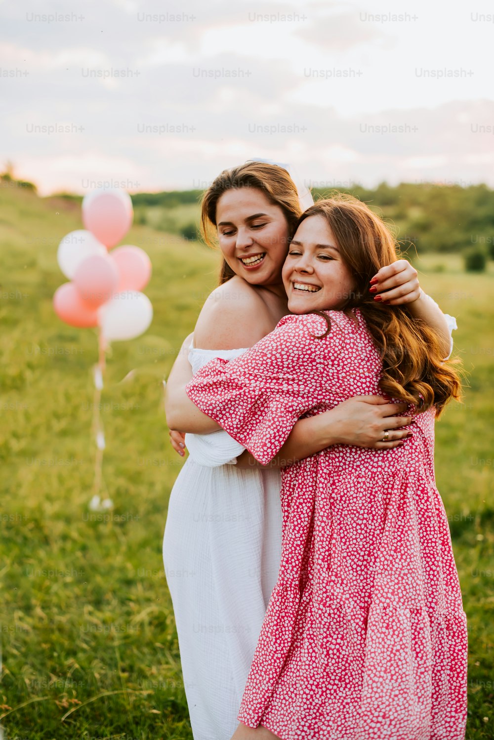 two women hugging each other in a field