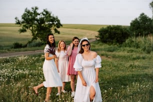 a group of women standing next to each other in a field