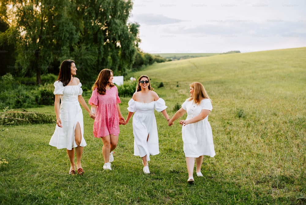 a group of women walking across a lush green field