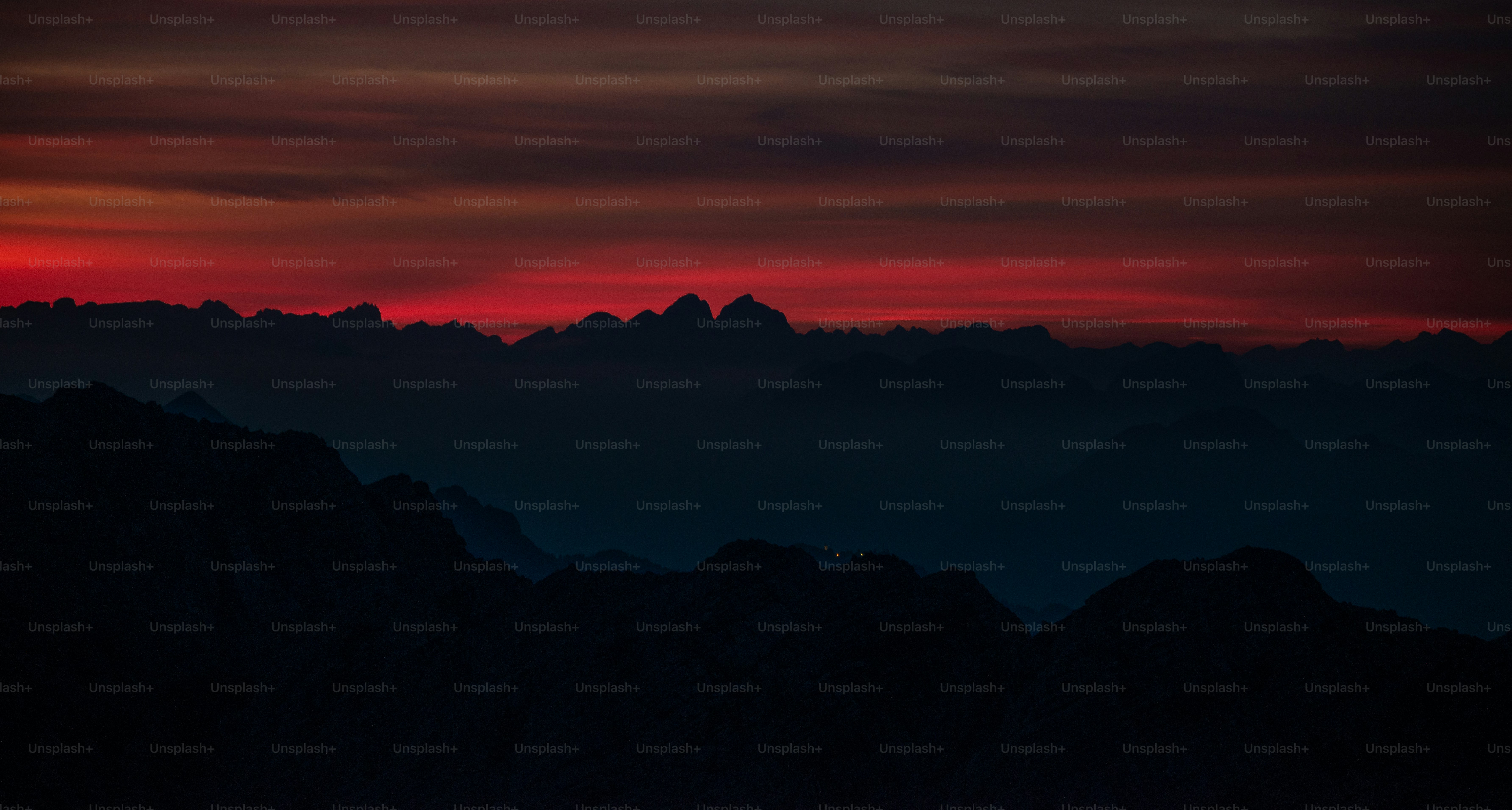 the sun is setting over a mountain range