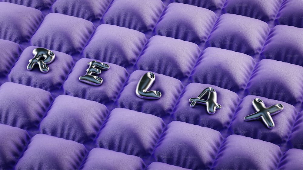 a group of metal letters sitting on top of a purple couch
