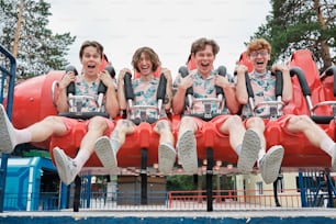 a group of young men riding on top of a roller coaster