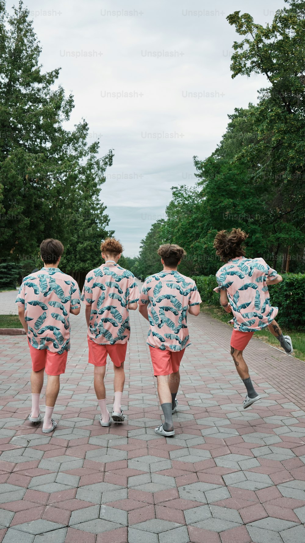 Un gruppo di giovani uomini che camminano lungo una passerella di mattoni