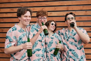 a group of people standing next to each other holding beer bottles