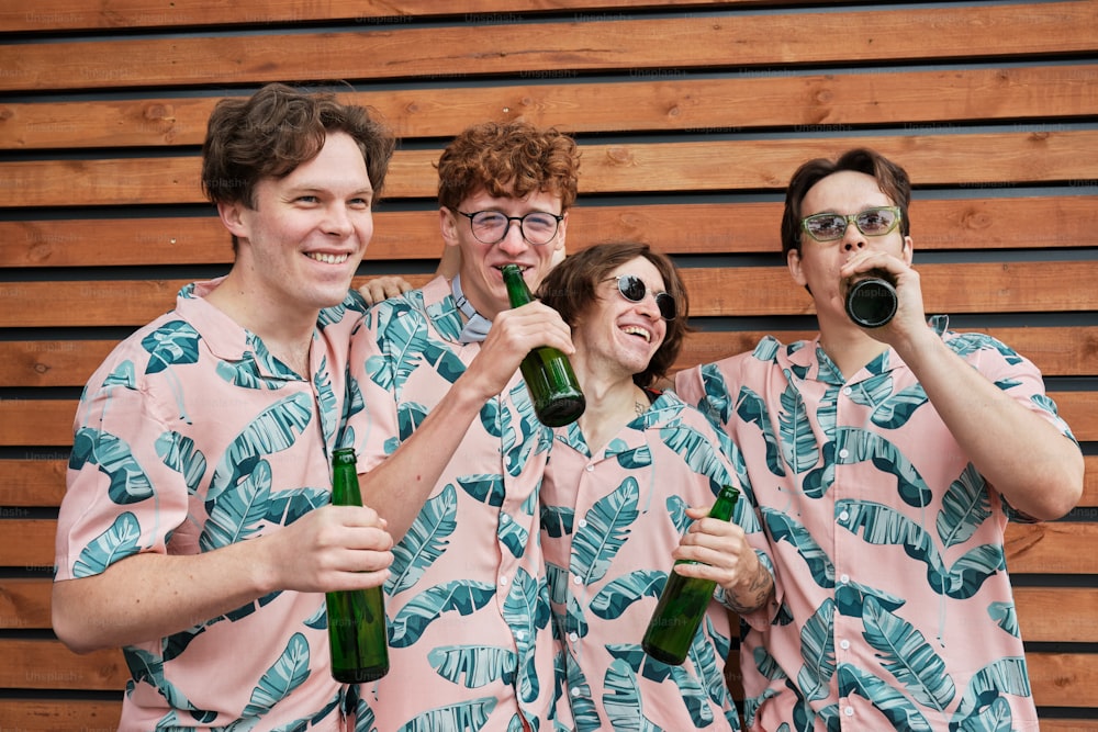 a group of people standing next to each other holding beer bottles