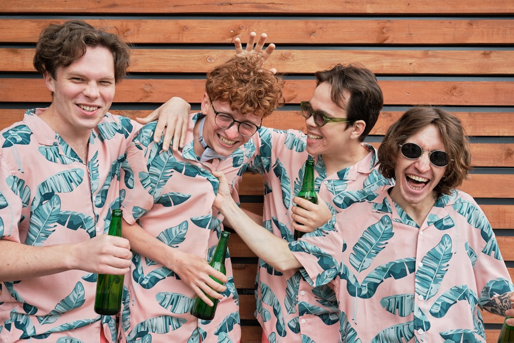 a group of men in matching pajamas holding beer bottles