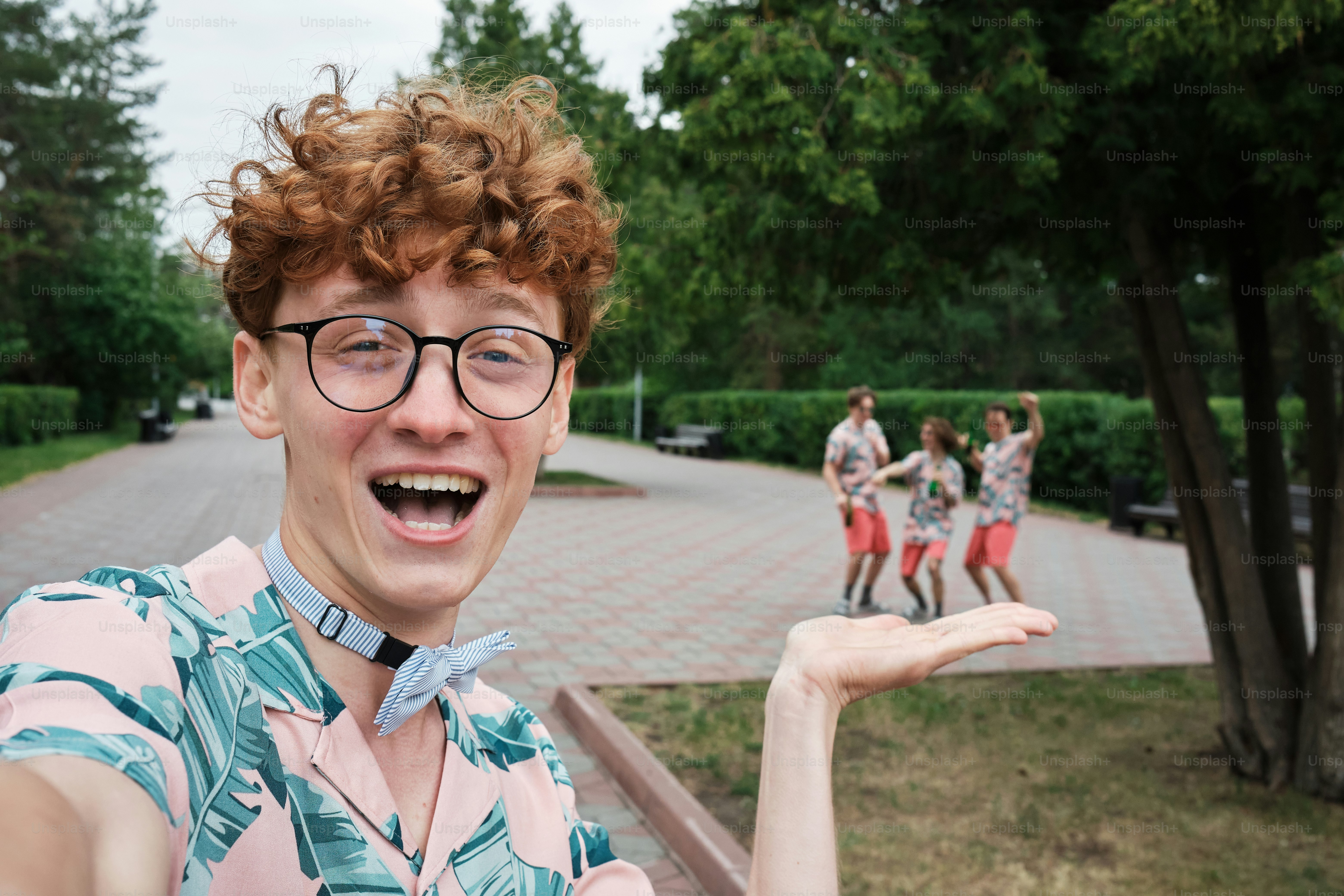 Un uomo con occhiali e papillon in piedi di fronte a un gruppo di persone