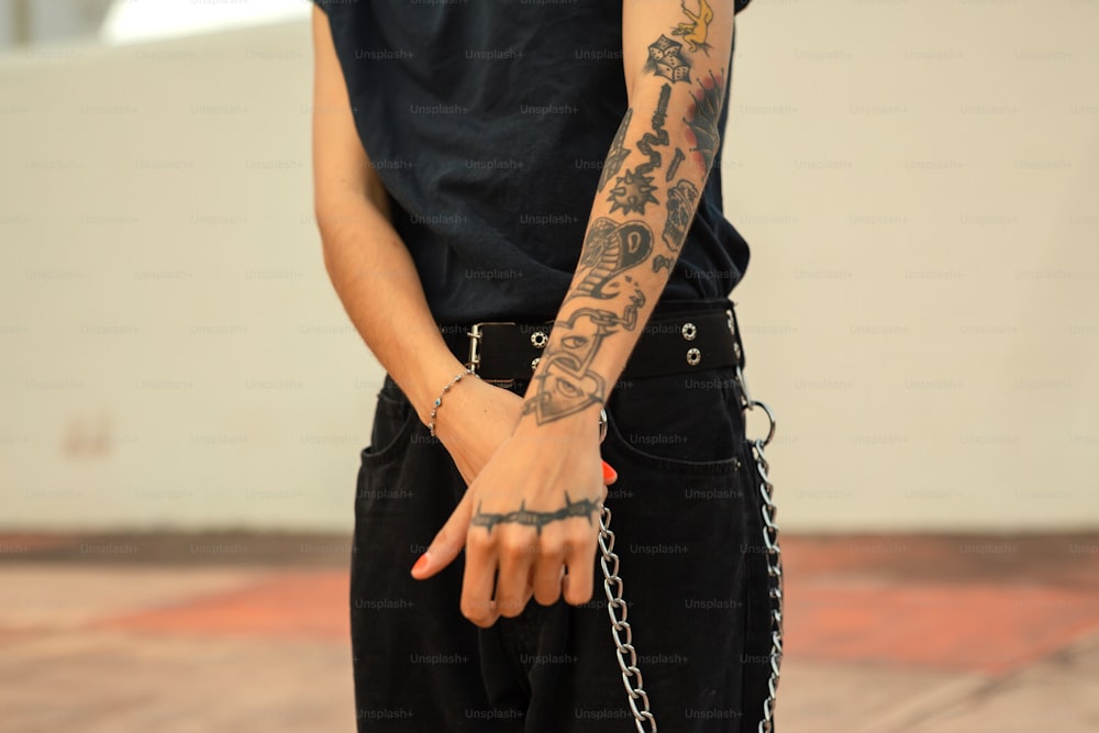 a man with a tattoo on his arm holding a chain