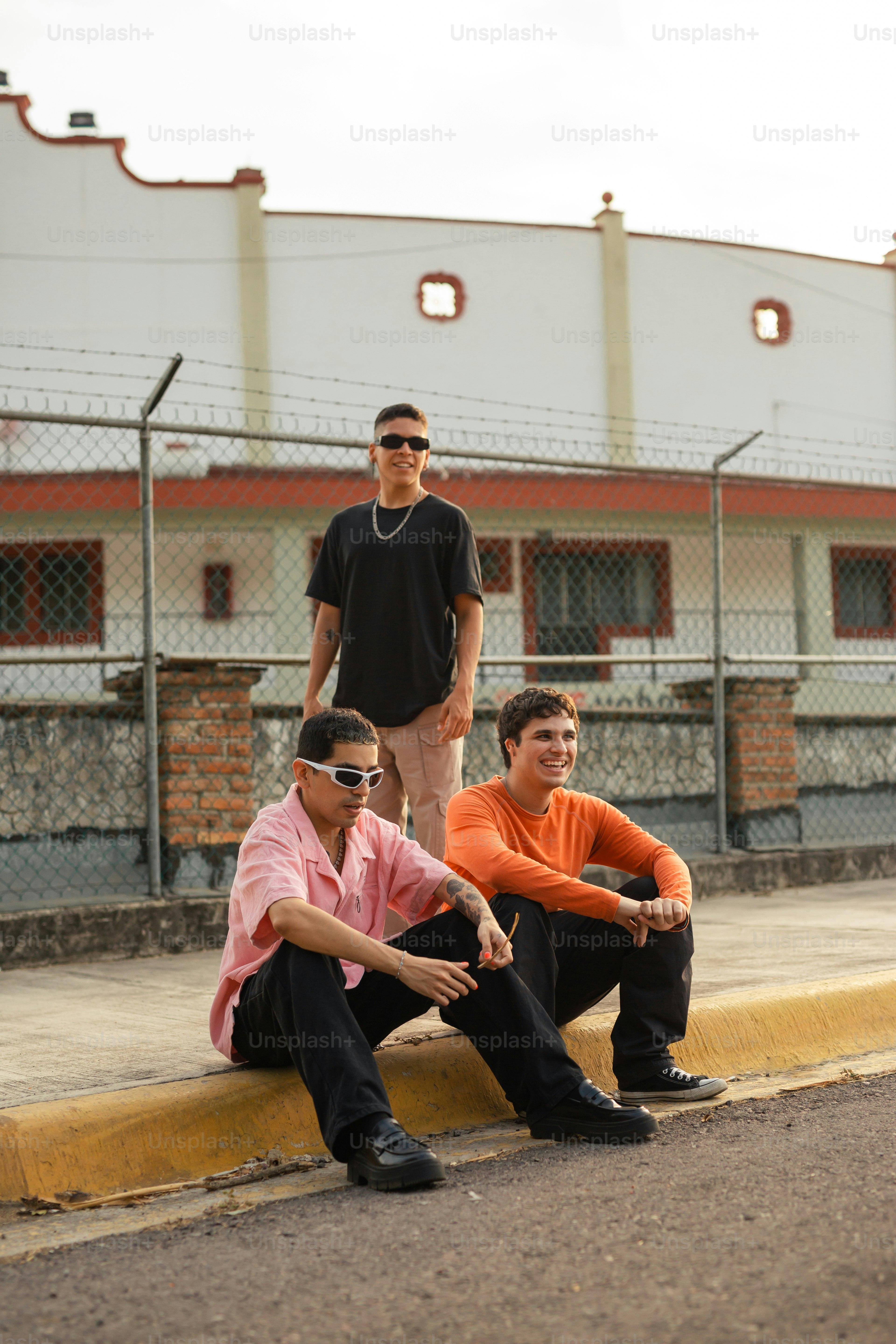a group of young men sitting on the side of a road