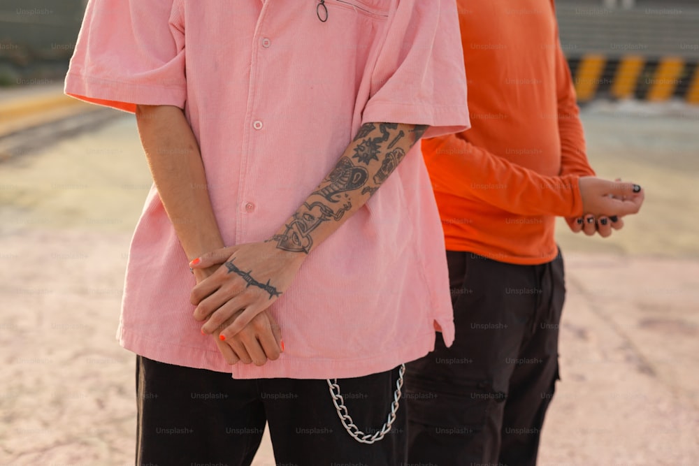 a man with a tattoo on his arm standing next to another man