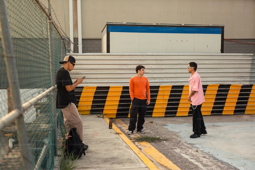 a group of men standing next to each other near a fence