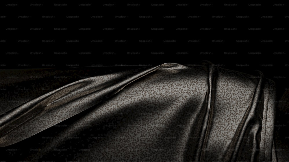 a close up of a black cloth with a black background