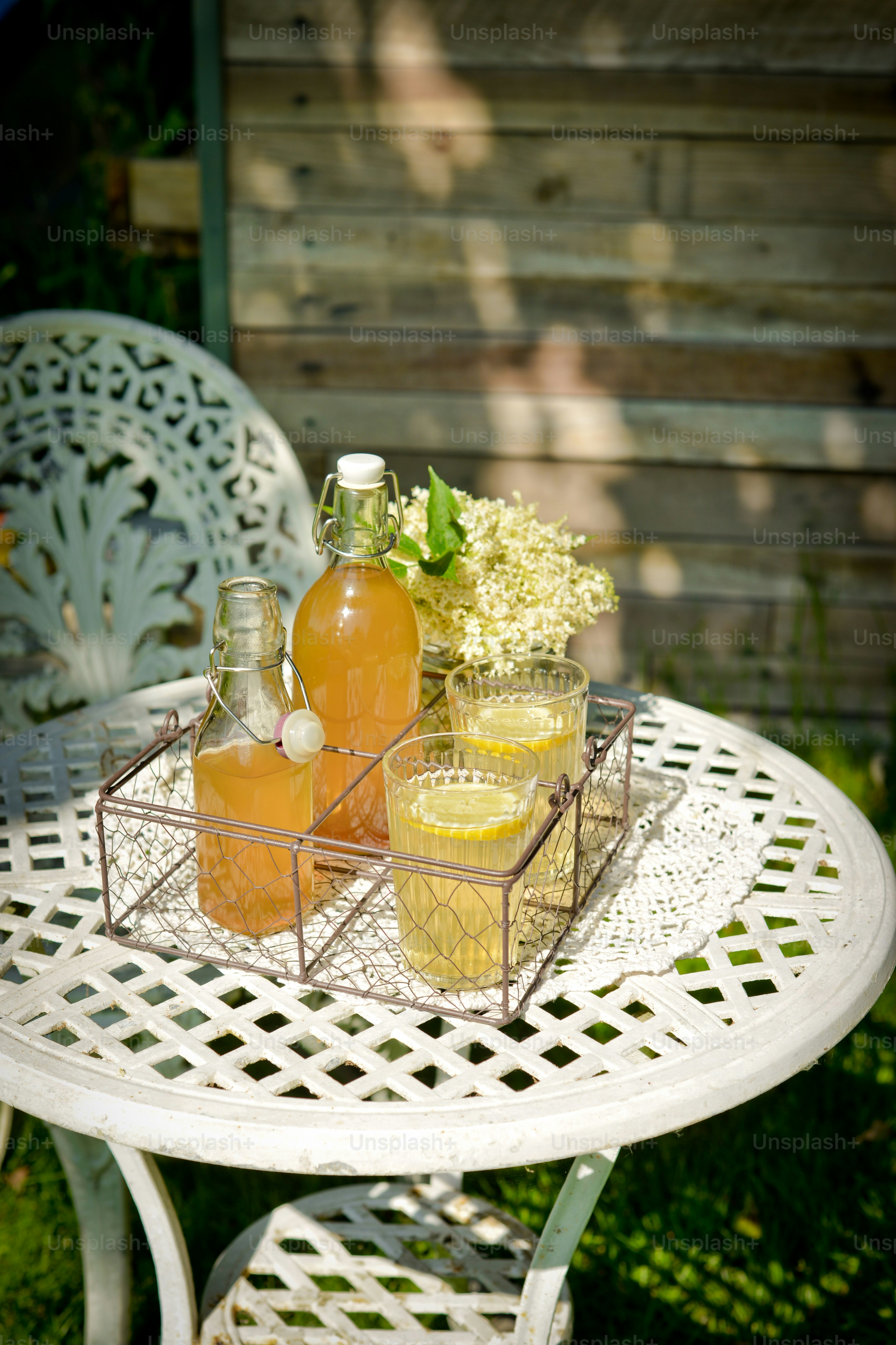 a white table topped with bottles of liquid and flowers