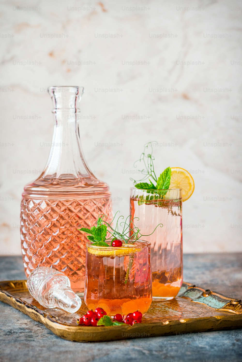 a pitcher of water and two glasses filled with liquid