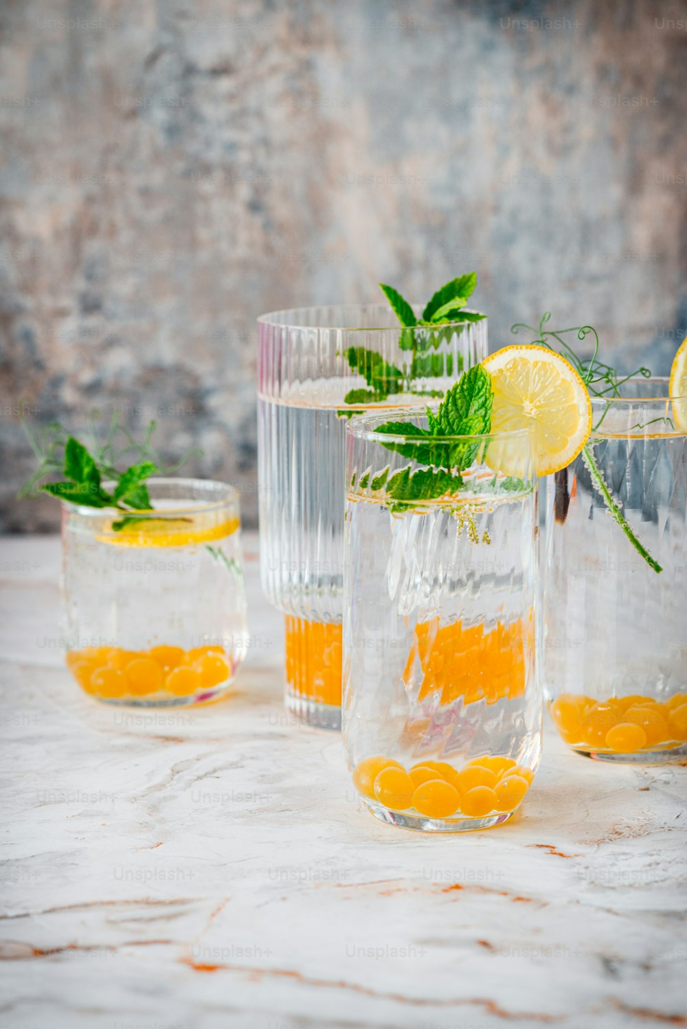 a group of glasses filled with lemons and mint