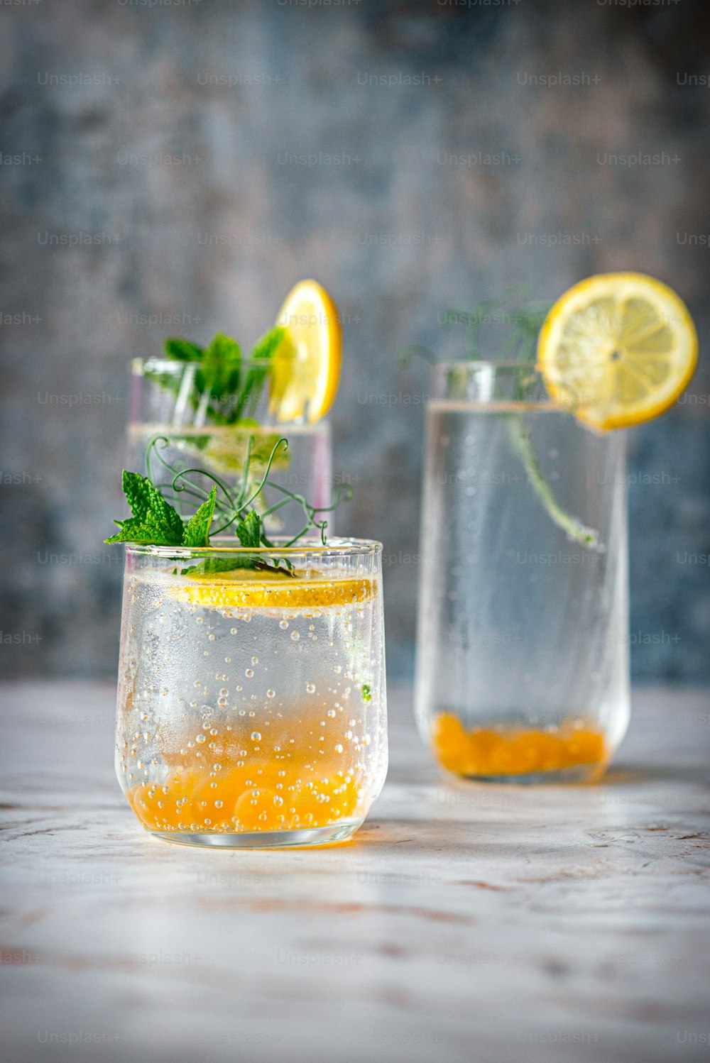 a couple of glasses filled with water and lemons