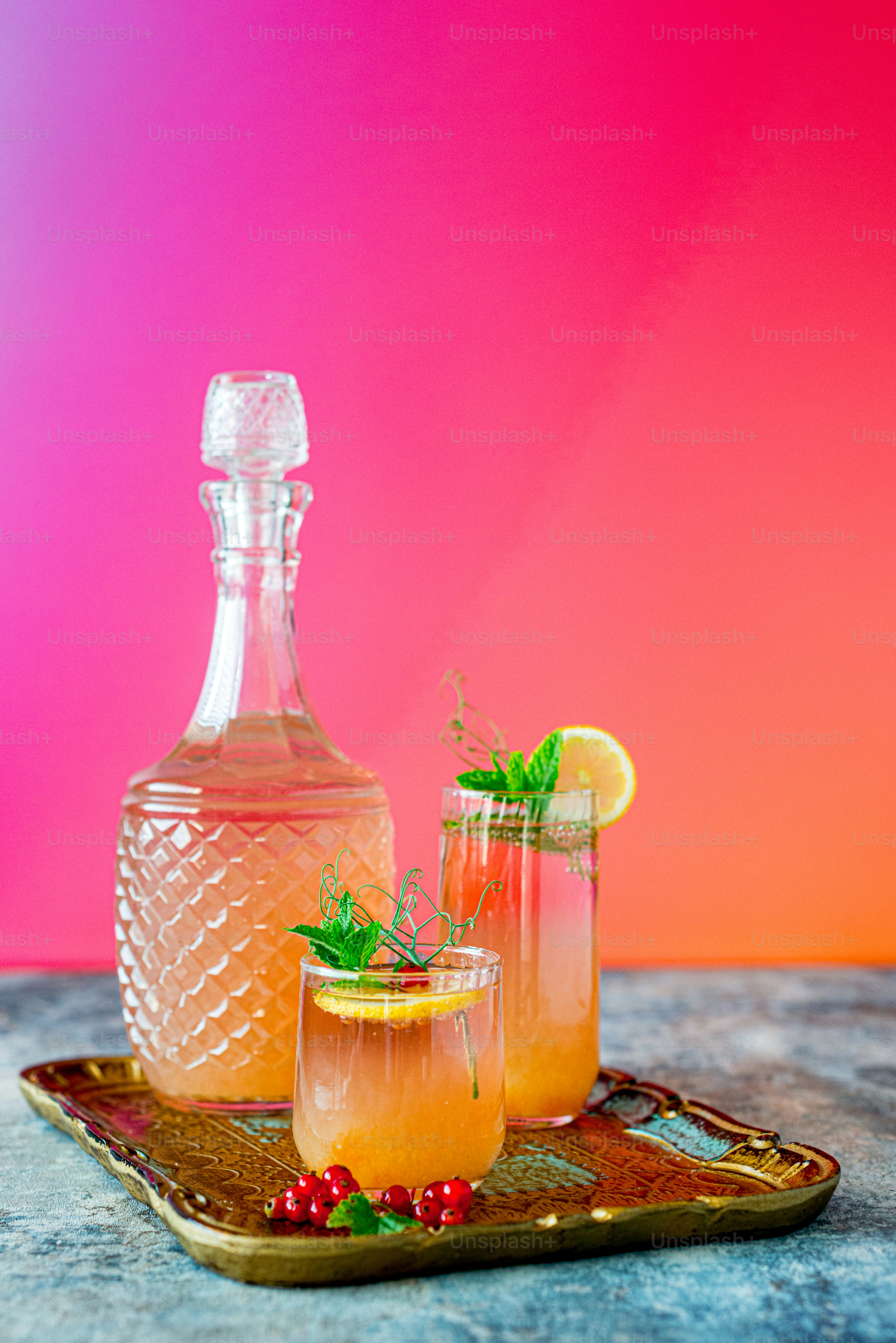 two glasses and a bottle of alcohol on a tray