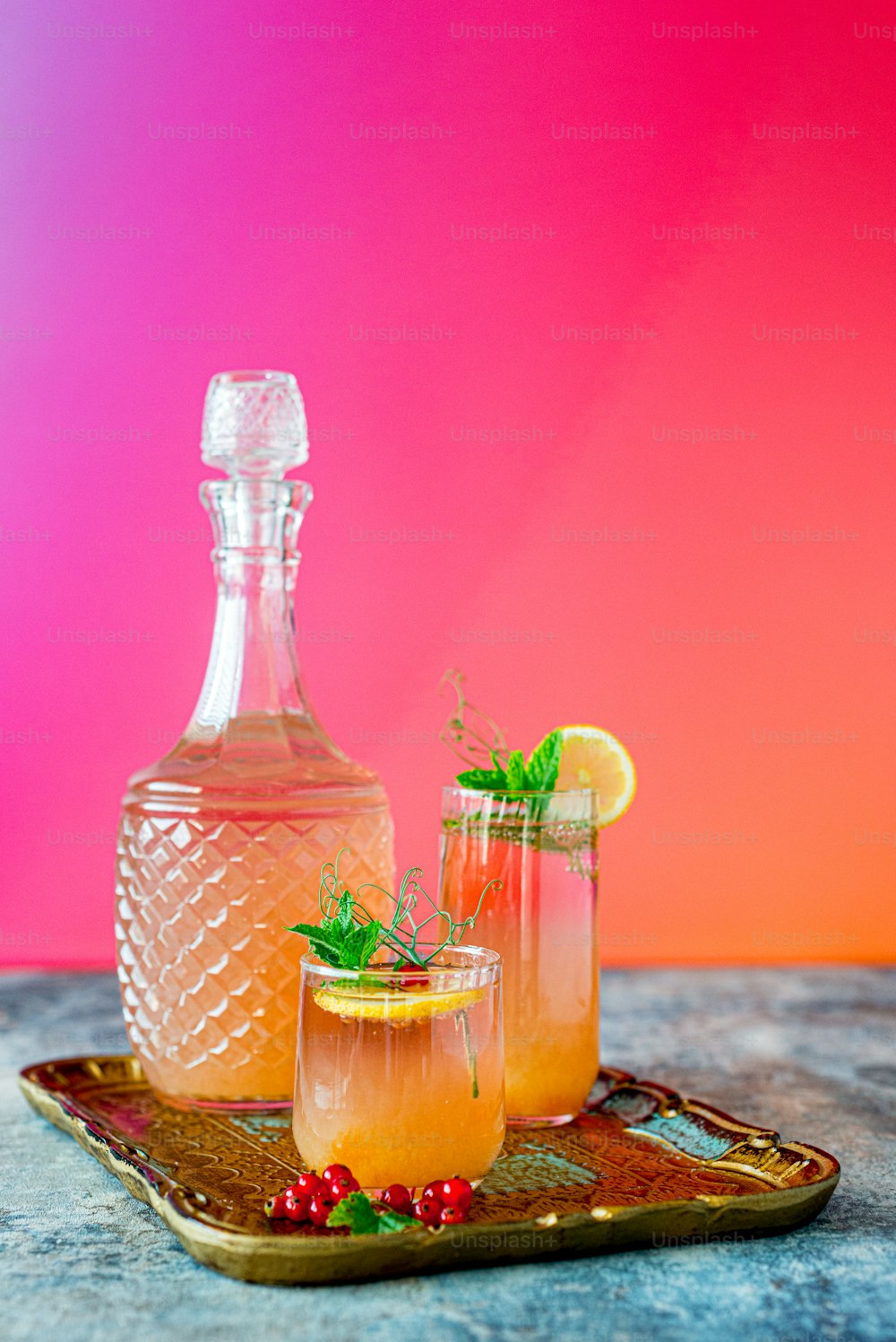 two glasses and a bottle of alcohol on a tray