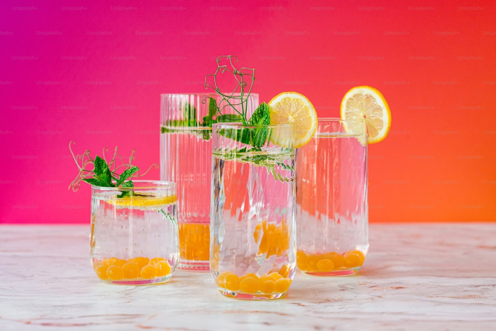 three glass vases filled with lemons and water