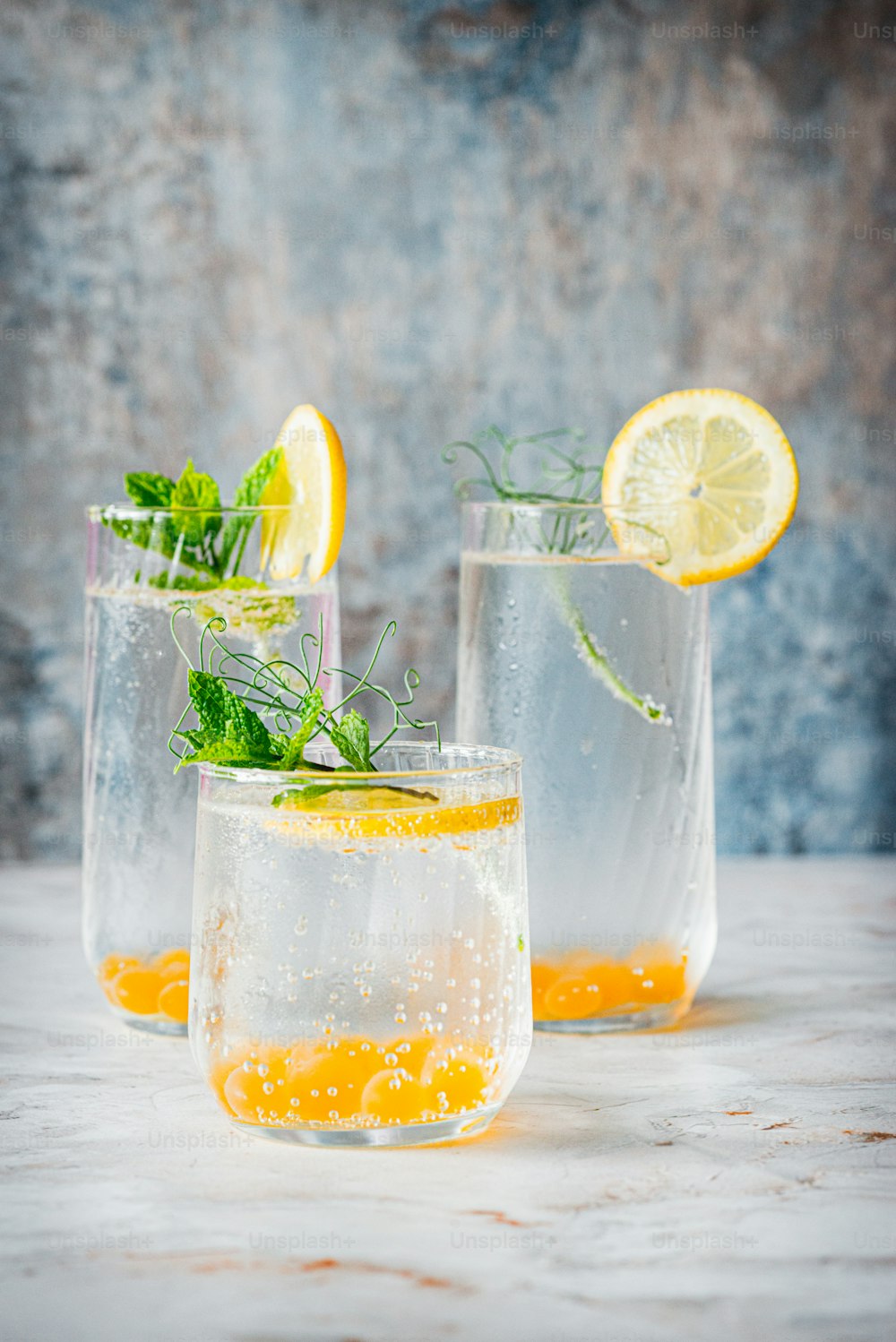 três copos cheios de água e rodelas de limão