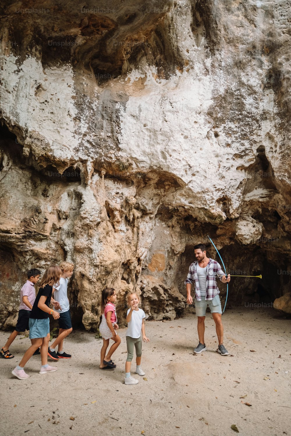 a group of people standing in front of a cave
