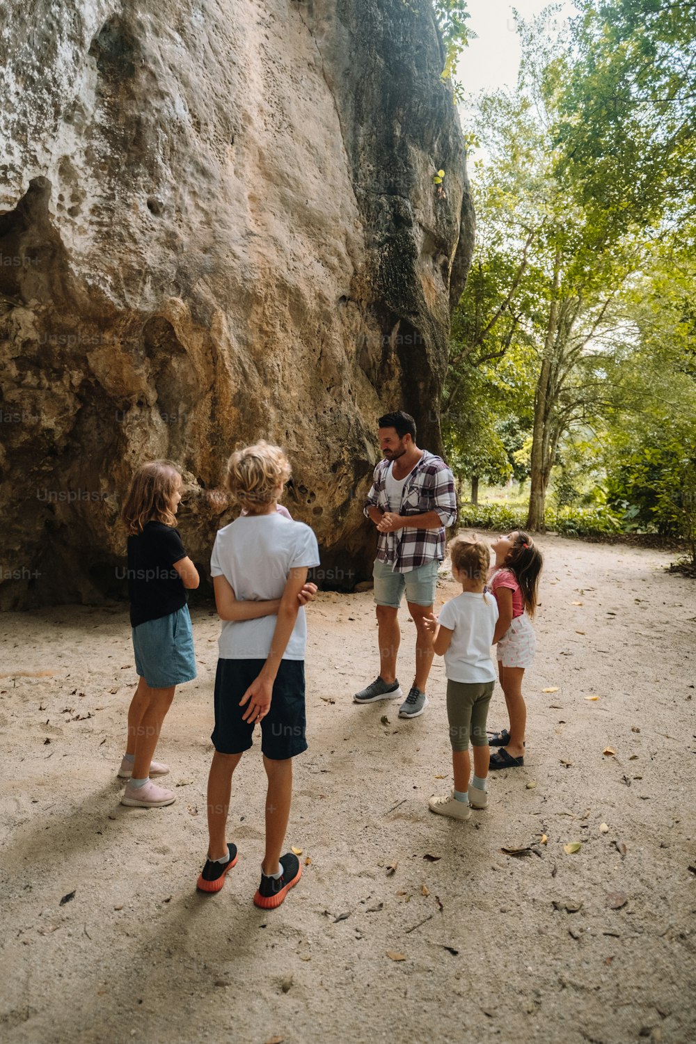 Un gruppo di persone in piedi di fronte a una grande roccia