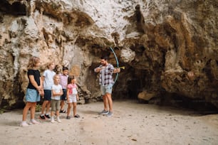 un gruppo di persone in piedi di fronte a una grotta