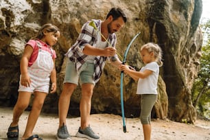 a man and two children are playing with a frisbee