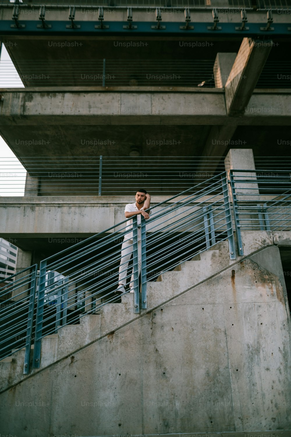 Un hombre parado en una barandilla de escalera al lado de un edificio