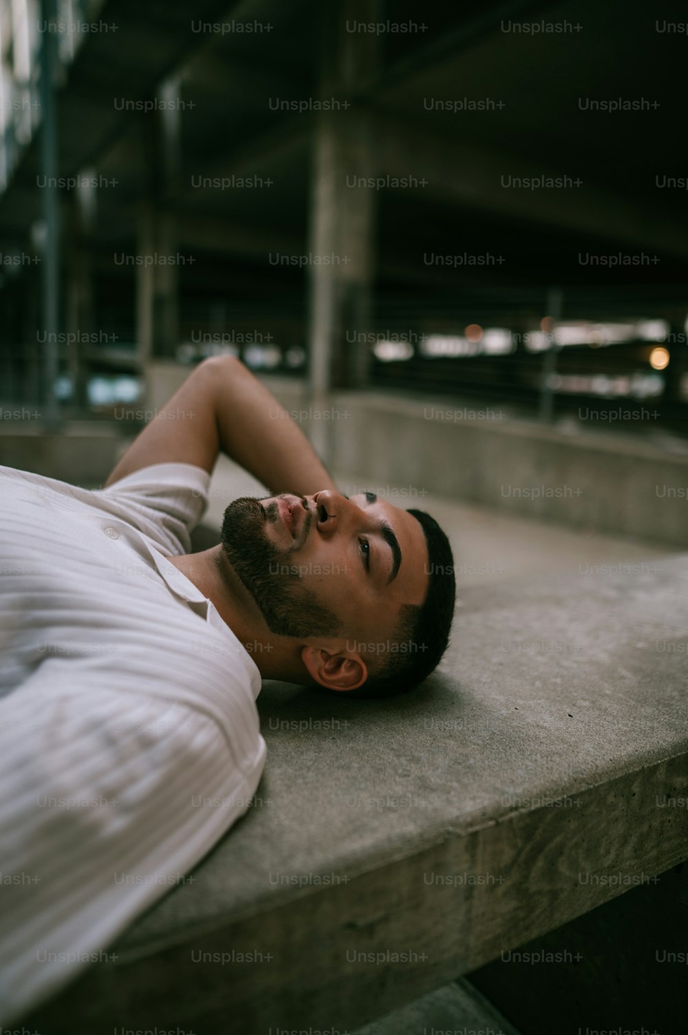 a man laying down on a concrete ledge