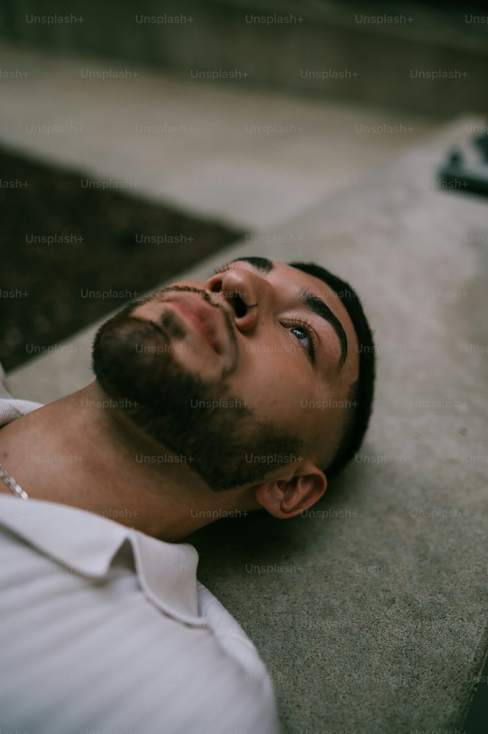 a man laying on the ground with his eyes closed