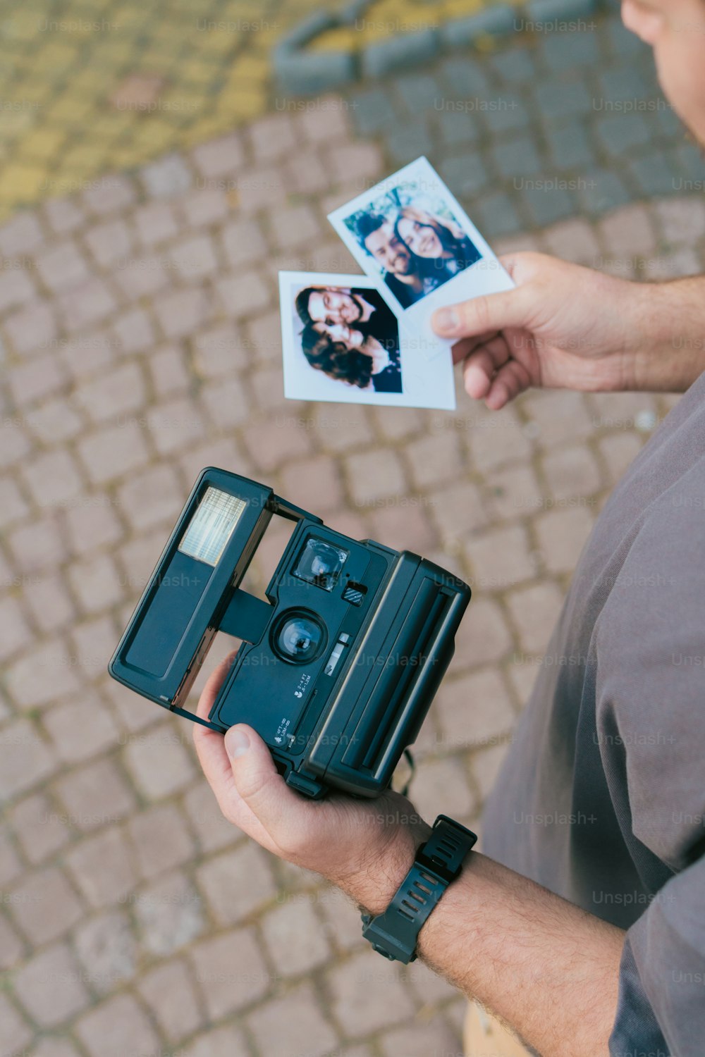 ein mann, der eine altmodische kamera und ein polaroid hält