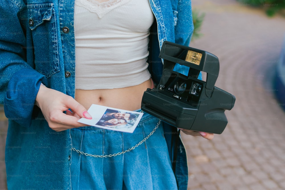 Une femme tenant un appareil photo et un polaroid