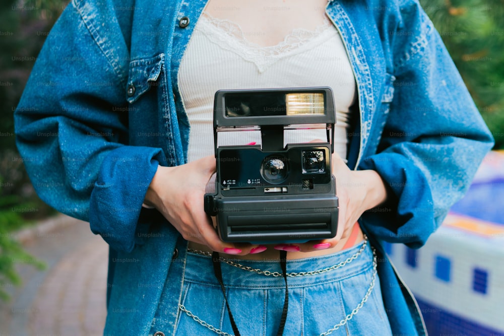Una mujer sosteniendo una cámara en sus manos