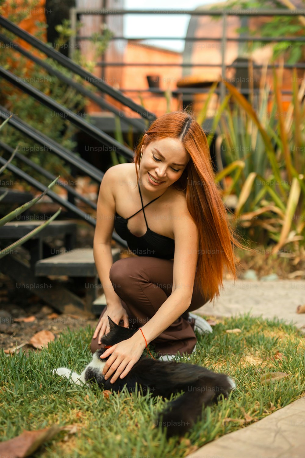 a woman with long red hair sitting on the grass