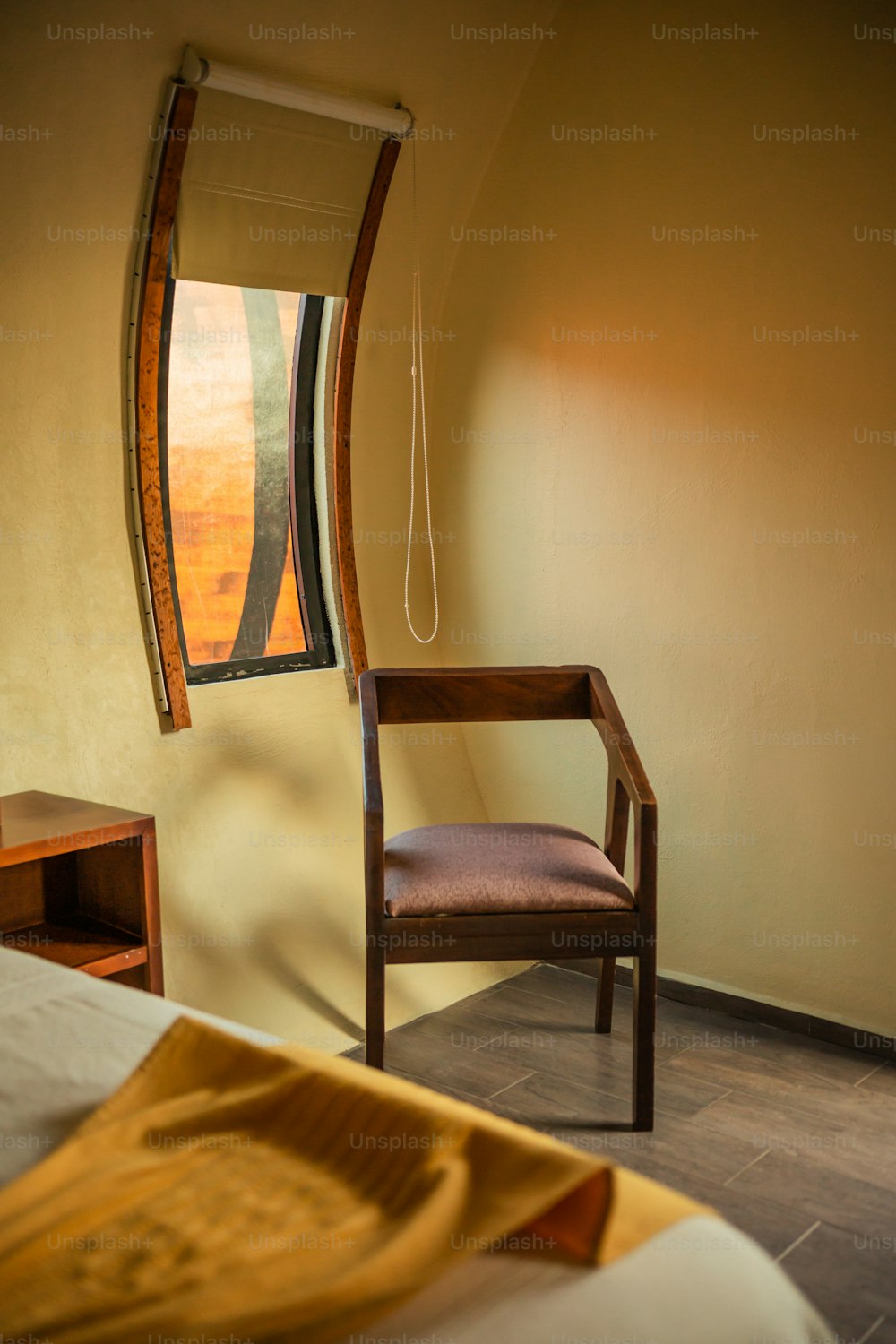 una sedia seduta in una camera da letto accanto a una finestra