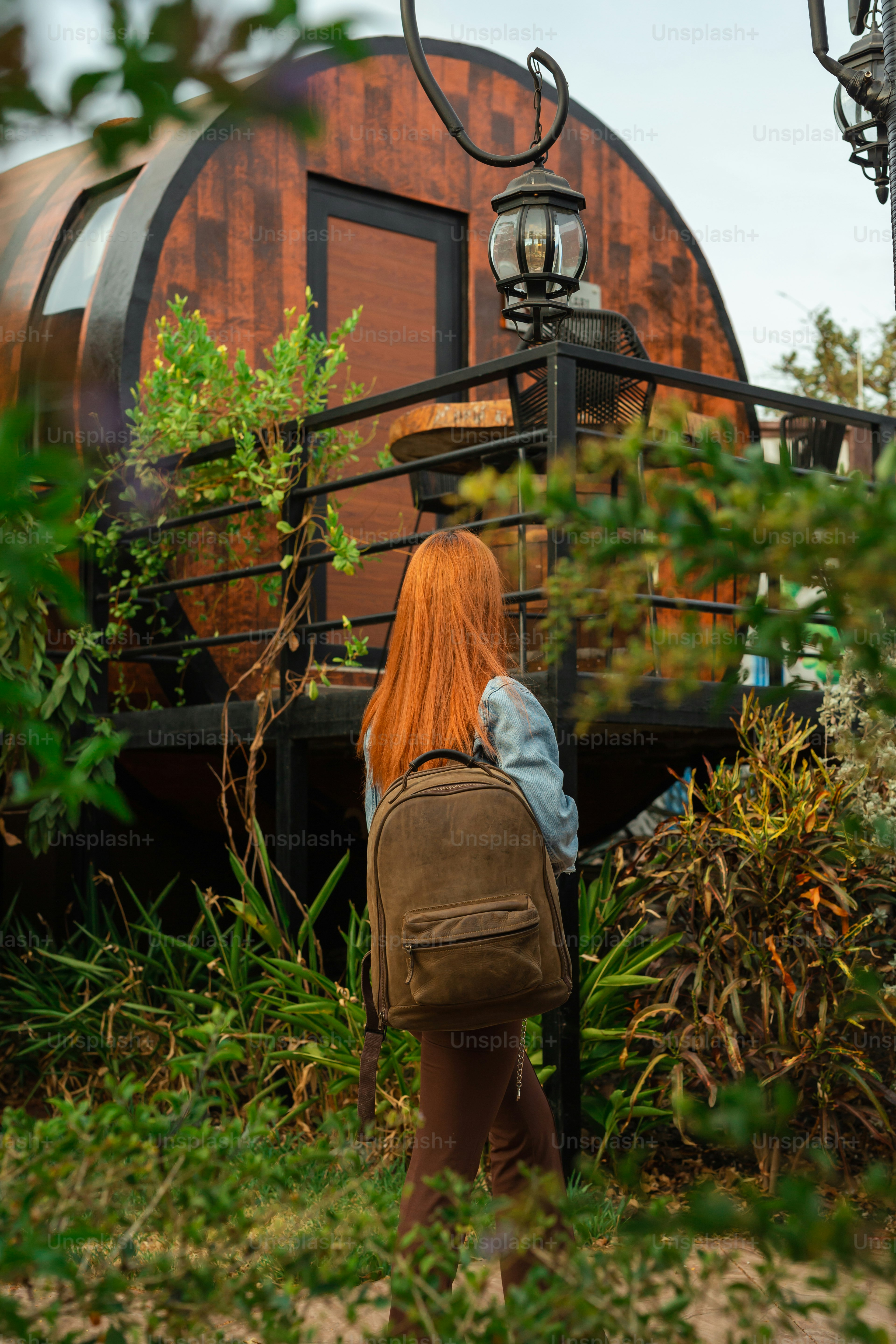 a woman with red hair is carrying a brown bag