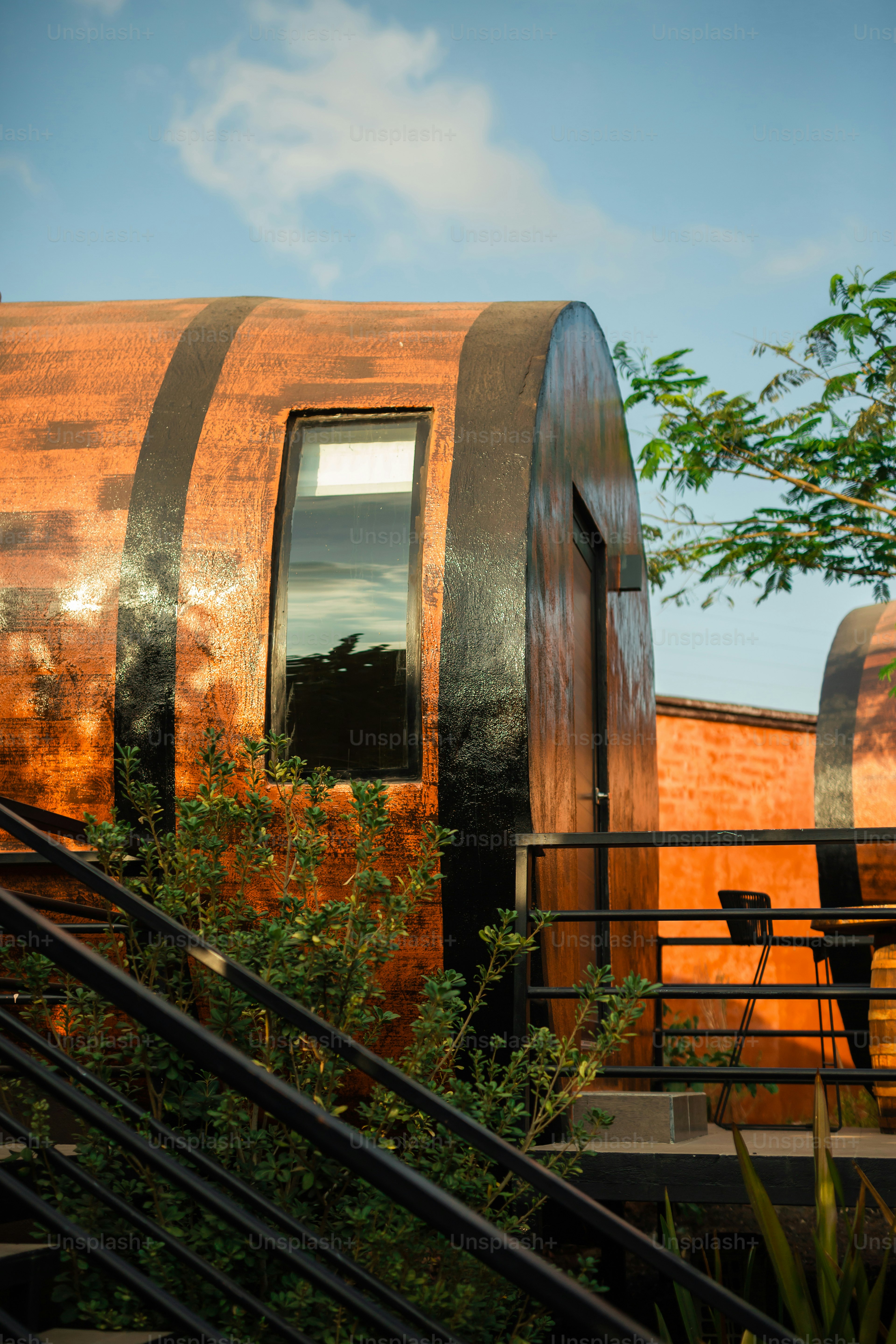 a train car sitting next to a tree and a building