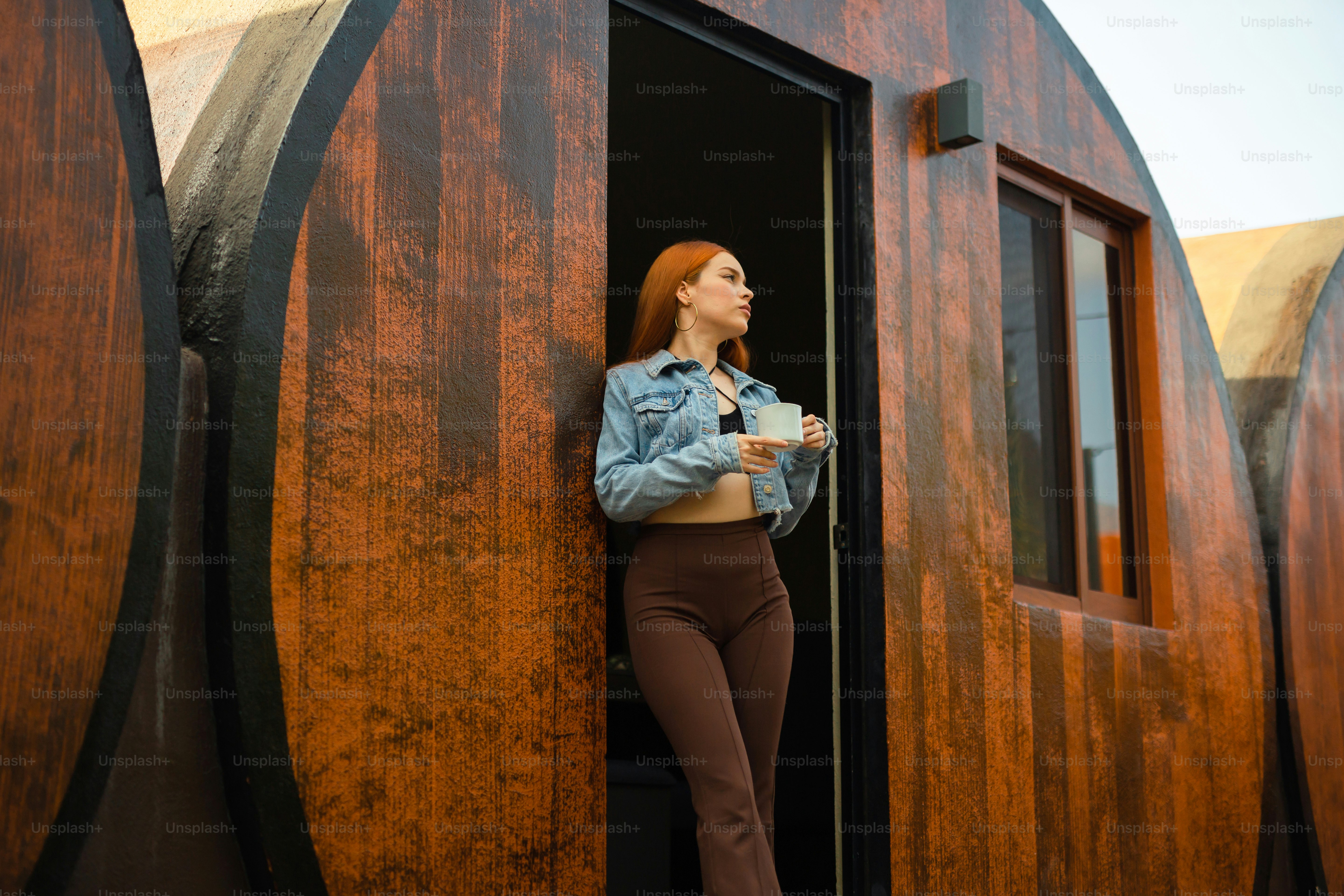 uma mulher em pé em uma porta com uma xícara de café